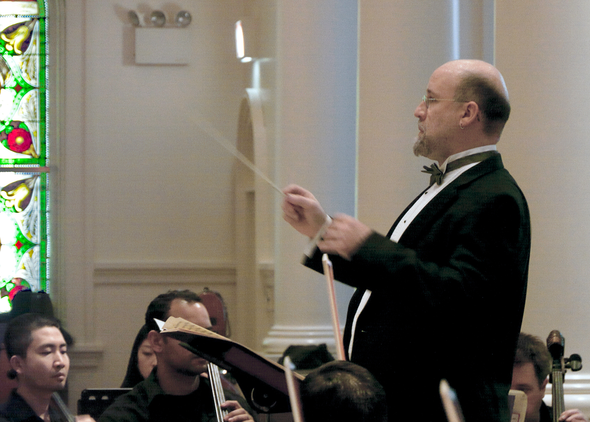 Composer Brian Wilbur Grundstrom conducting the premiere of Jubilation! Dance for Orchestra by the Queer Urban Orchestra